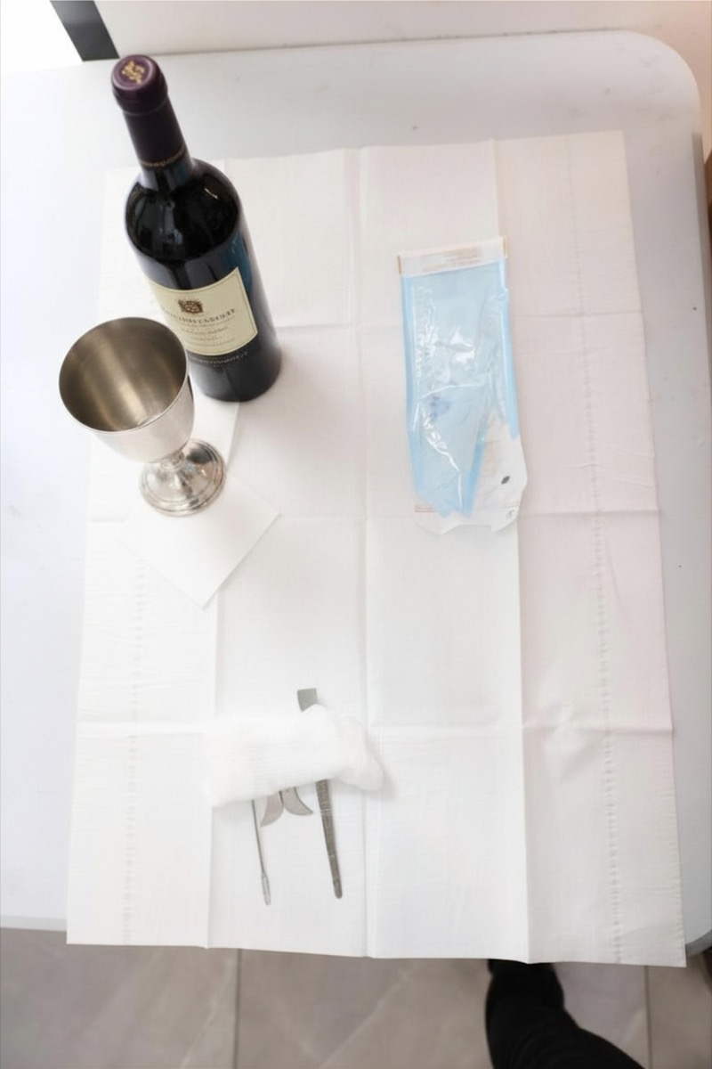 Bris setup — wine, kiddush cup, and instruments laid out with care